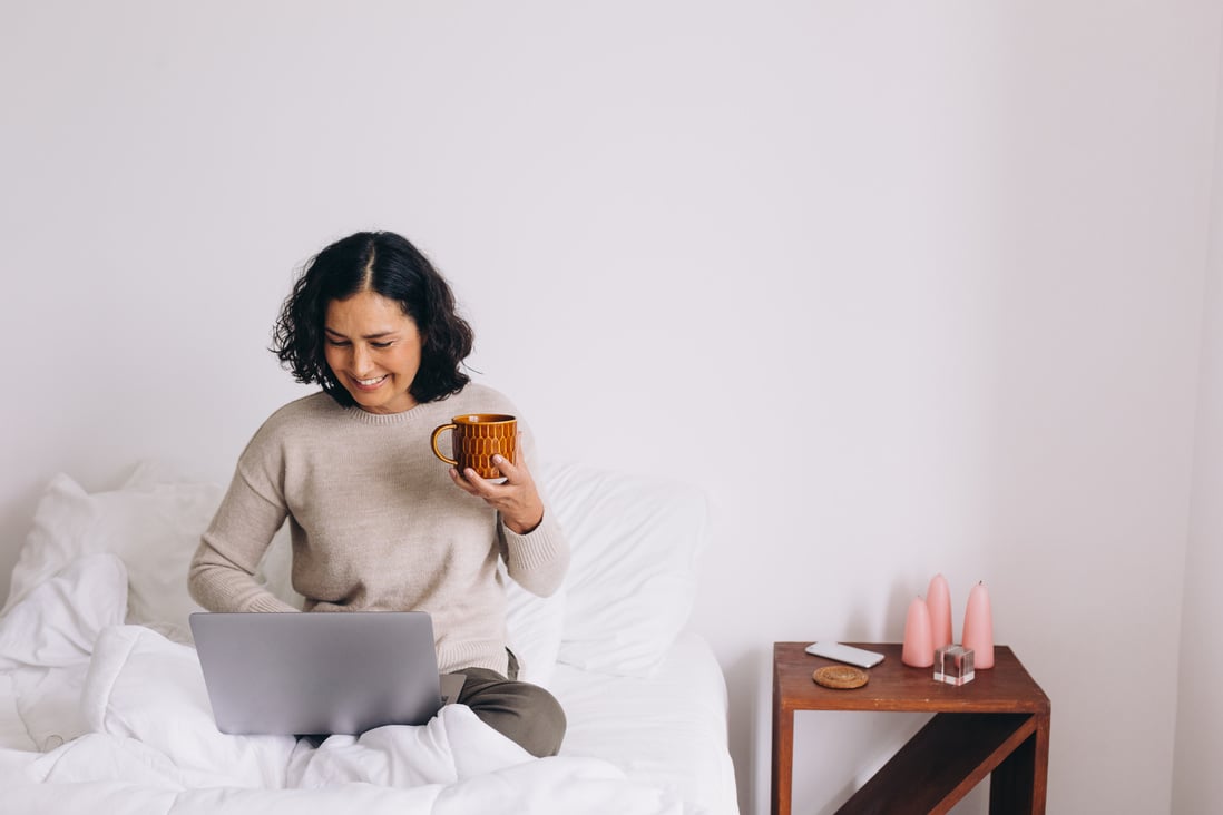 Woman Using Laptop on Bed